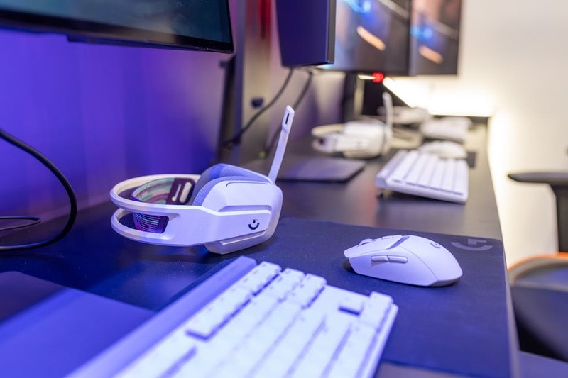 Ein kabelloses Gaming Headset, das auf einem Ladeständer steht, im Hintergrund ein aufgeräumtes Gaming-Setup.