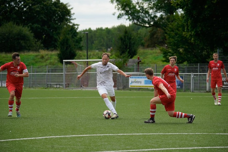 Competitive soccer players in action during a match on a green field, showcasing teamwork and athlet