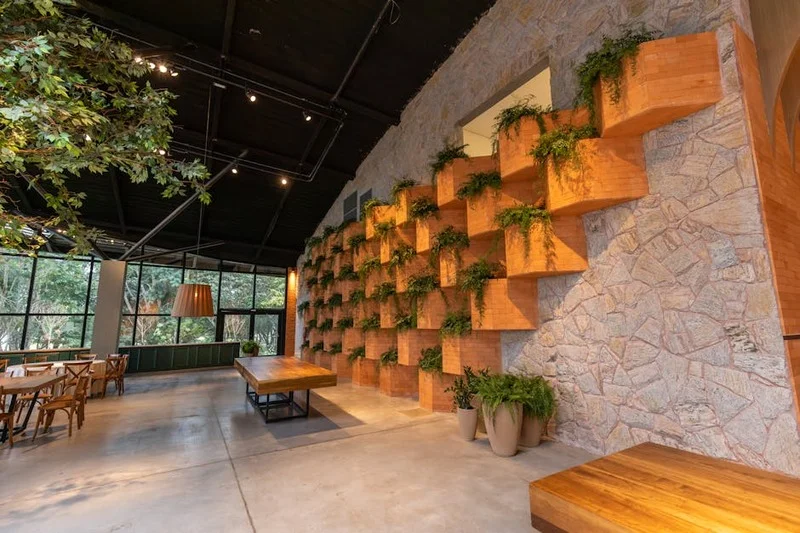 Interior of a modern vegan restaurant 'Wurzel & Blatt' with minimalist wooden tables and lush green plants