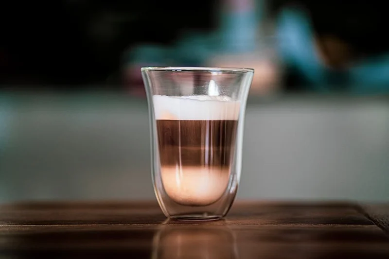 Geschichteter Latte Macchiato in einem hohen Glas mit Espresso zwischen Milch und Schaum