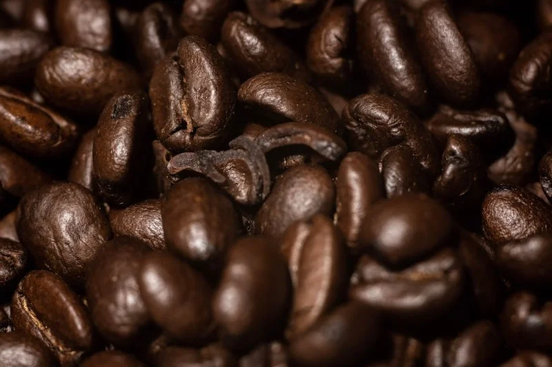 Deep dark brown, shiny dark roasted coffee beans