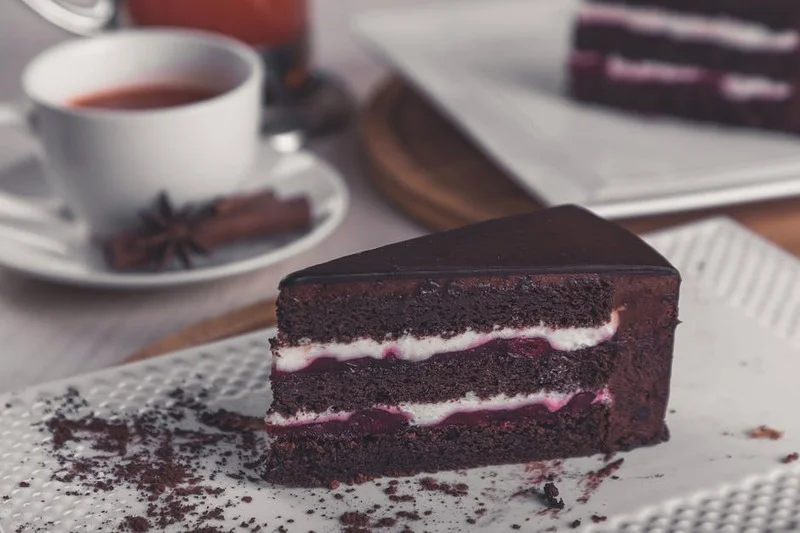 Delicious slice of vegan and gluten-free chocolate cake topped with fresh berries