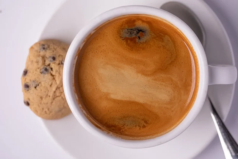 Close-up of a fresh espresso shot, showcasing its thick, golden-brown crema